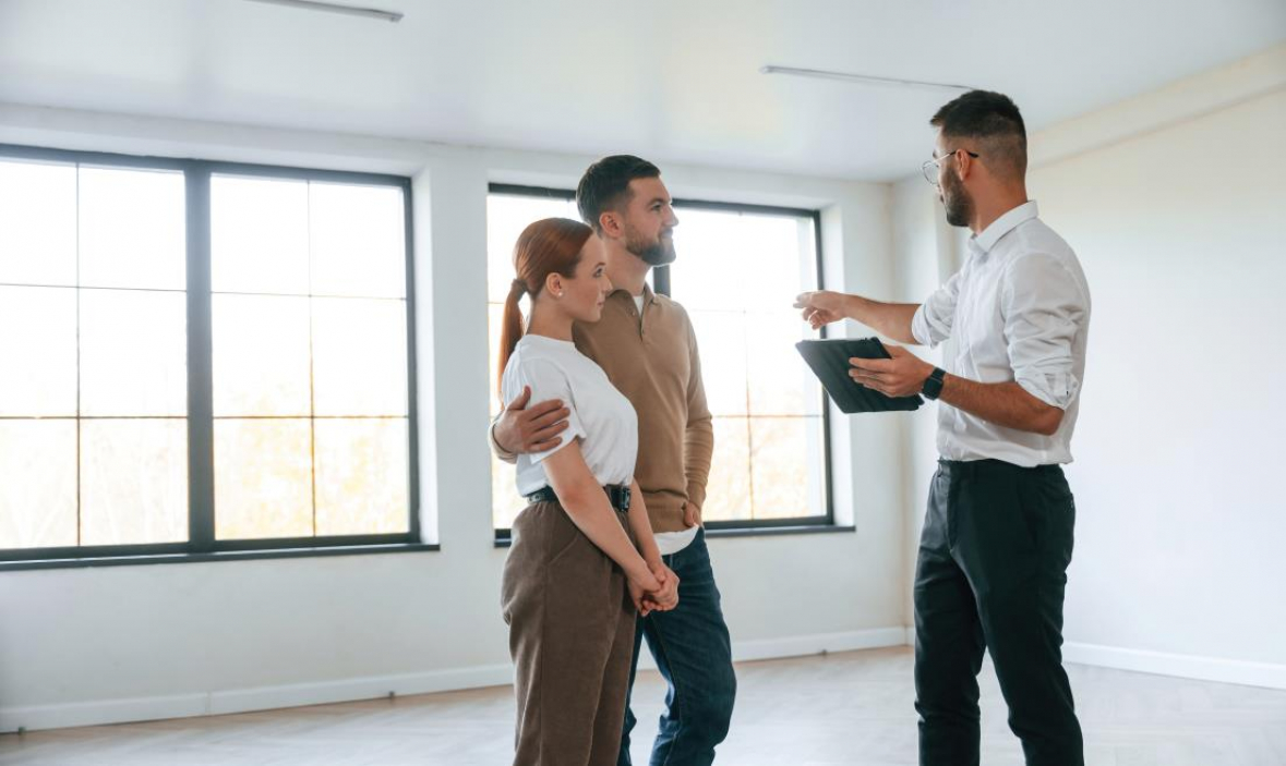 A realtor walking a couple through an empty home that is up for sale